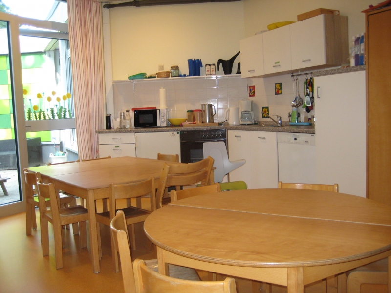 Das Bild zeigt eine Küche mit Esstischen.