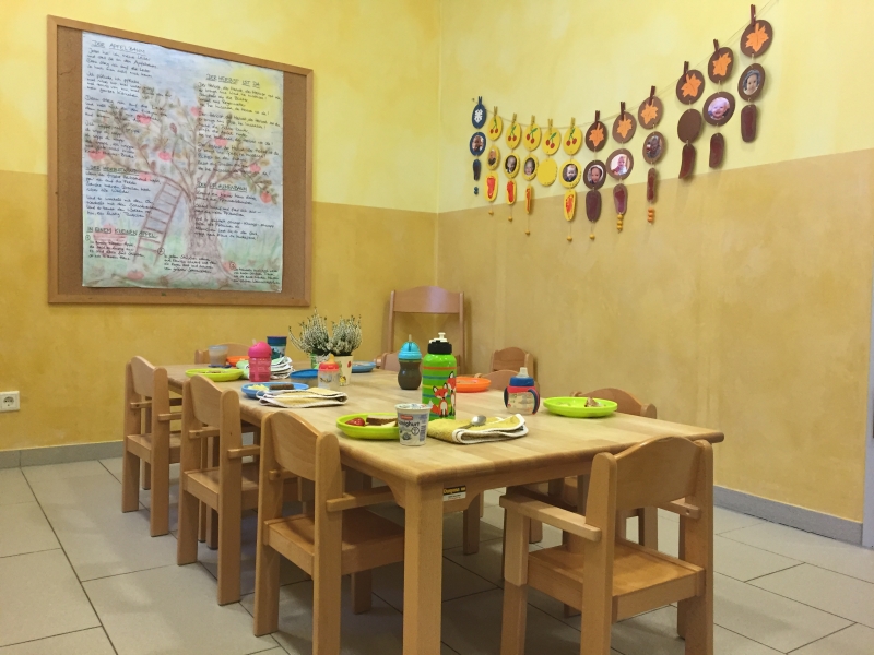 In der Küche befindet sich ein langer Holztisch mit kleinkindgerechten Stühlen zum gemeinsamen Essen.
Der Geburtstagskalender der Kinder an einer Wand zu sehen.
